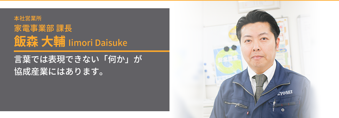 こちらを見て微笑む家電事業部課長・飯森大輔