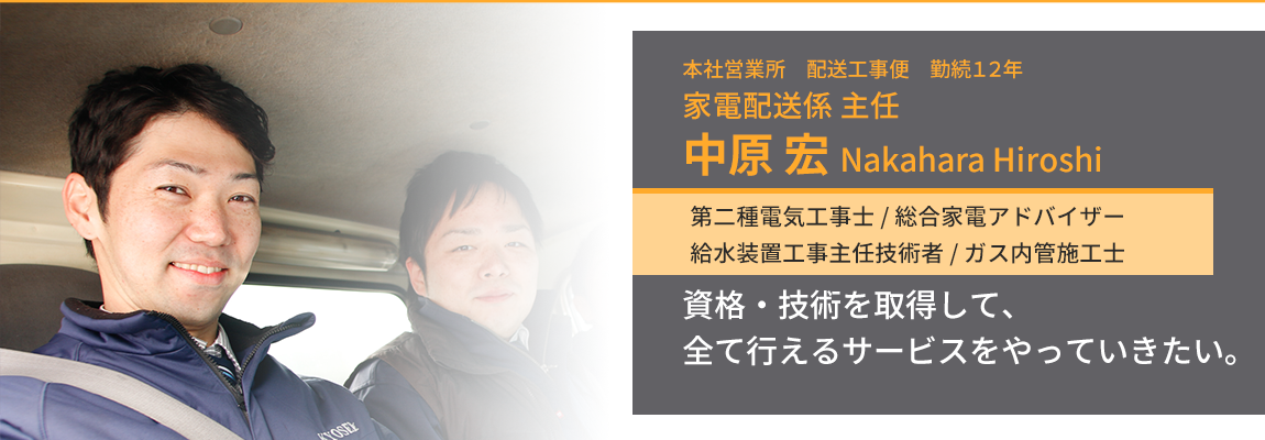 トラックの窓からこちらを見て笑う家電配送係主任・中原宏